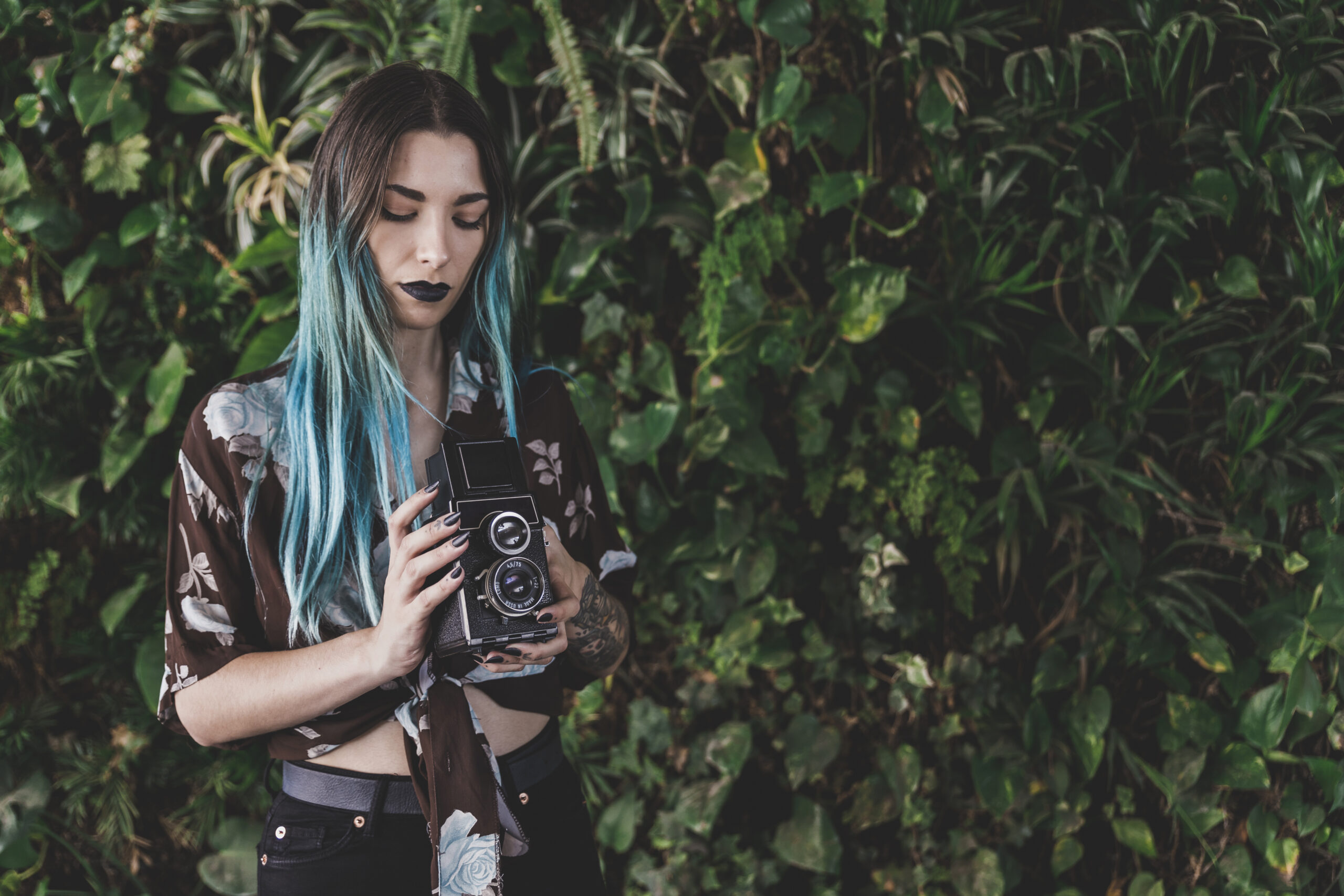 young-woman-holding-old-retro-styled-camera-hand
